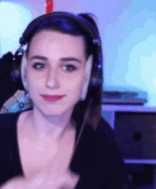 a woman wearing headphones is looking at the camera and making a funny face .