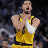 a basketball player with the number 0 on his jersey is holding his neck