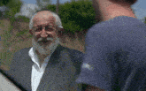 a man wearing a blue shirt that says ' a ' on it is talking to another man