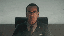 a man in a suit and tie sits in a chair with a badge on his chest