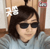 a woman wearing sunglasses and a sticker that says geu on it