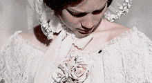 a woman in a white dress with a flower on her chest