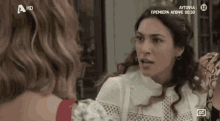a woman talking to another woman on a tv screen that says a hd