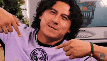 a man wearing a purple shirt with the letter a on the front