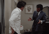 a man in a suit and tie is talking to another man