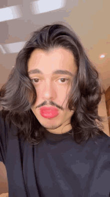 a man with long hair and a mustache has a red lip