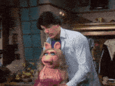 a man in a white shirt is holding a pink piggy doll