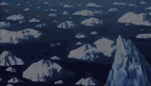 an aerial view of icebergs in the ocean with mountains in the background
