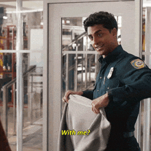 a man in a blue uniform is holding a blanket and asking with me