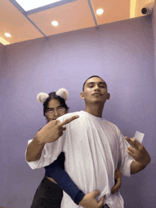 a man and a woman are posing for a picture and the woman is wearing ears