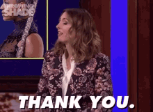 a woman in a floral suit is saying thank you
