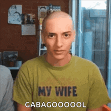 a man with a bald head is wearing a green shirt that says my wife