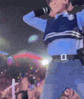 a man in a blue sweater is dancing in front of a crowd of people