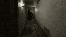 a black and white photo of a hallway with a person walking down it