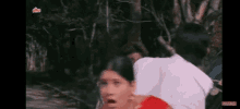 a man and woman are standing next to each other in the woods .