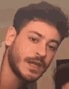 a close up of a man 's face with a beard and mustache .
