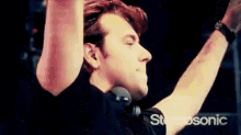 a man wearing headphones and a black shirt with the word stereosonic on the bottom