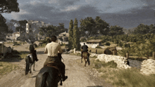 a group of men riding horses down a dirt road with a castle in the background