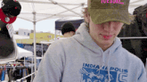 a man wearing a tuesday hat and an indianapolis sweatshirt