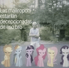 a man is standing next to a group of ponies on a road .