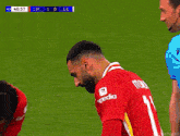 a soccer player with the number 11 on his jersey is kneeling down