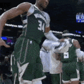 a basketball player wearing a green jersey with the number 34