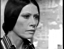a black and white photo of a woman in a striped shirt .