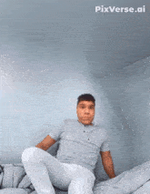 a man wearing headphones sits on a bed with pixverse.ai written in the corner