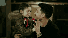 a man is holding a little girl in his arms with the hashtag @marecomenta on the bottom right