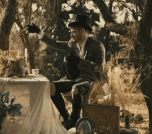 a man in a top hat is sitting at a table