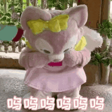 a stuffed animal with a bow on its head is standing on the ground .