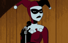 harley quinn is speaking into a microphone in a cartoon