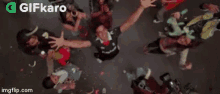 a group of people are sitting on a couch at a party with confetti falling .