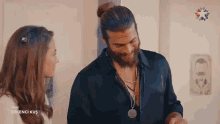 a man and a woman are standing next to each other in a room .