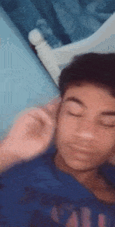 a young boy is laying on a bed with his eyes closed .