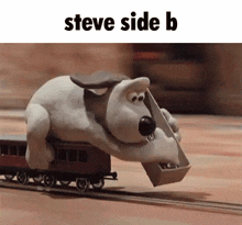 a stuffed animal is riding a train with a bucket on its back .