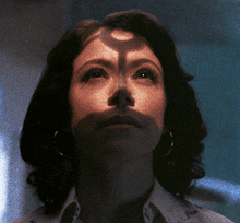 a close up of a woman 's face with a shadow on it