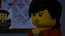 a lego girl stands in front of a bulletin board with a drawing of a man on it