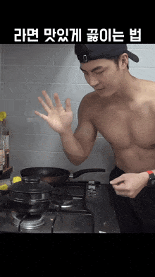 a shirtless man in a baseball cap is cooking on a stove in a kitchen