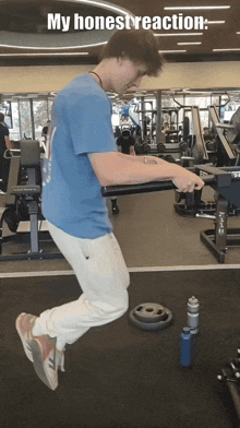 a man in a blue shirt is jumping in the air in a gym with a caption that says my honest reaction