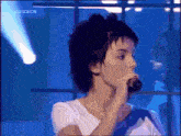 a woman singing into a microphone with a bbc logo on the bottom