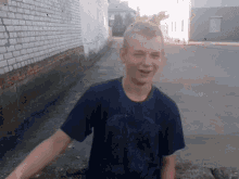 a young boy wearing a blue t-shirt with a picture of a bird on it