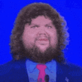 a man with a beard wearing a suit and tie