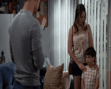 a man and a woman are standing next to a boy