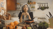 a woman with blue hair is cooking in a kitchen and holding a stick