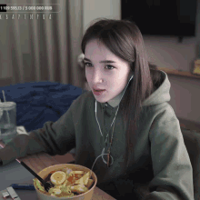 a woman is sitting at a table with a bowl of food in front of her and a sign that says 1 109 595.13