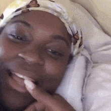 a woman wearing a headband with butterflies on it is smiling while laying in bed .