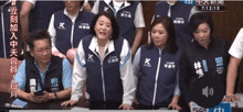 a group of people are standing around a table with chinese writing on them .