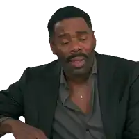 a man in a suit covering his face with his hands