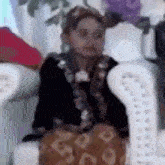 a little girl is sitting in a chair wearing a hat and a black jacket .
